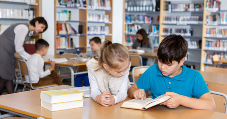 Fototapeta na wymiar Girl and boy studying in school library