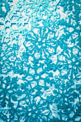 Full frame wintry background of textured glittery blue snowflakes