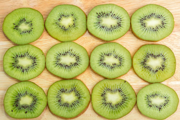 kiwi cut into slices on a wooden Board laid out in a row