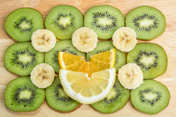 fruit slicing kiwi, banana, orange and lemon on wooden Board
