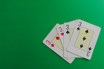 four 3 cards of a poker deck over a green background