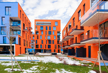 Fototapeta premium Colorful Modern residential apartment and flat building exterior in Salzburg, of Austria. New luxury house and home complex of red color. City Real estate property and condo architecture.