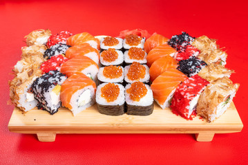Sushi set of rolls and poppies, with salmon and caviar. With tuna and krill California and Philadelphia. Close-up.