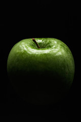 Appetizing green apple on a black background. Close-up