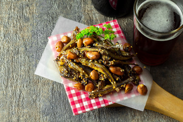 Tazukuri, candied sardines served with red beer. Dried sardines lightly coated with honey, roasted sesame and peanuts.