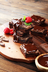chocolate brownie cake dessert with raspberries and spices on a wooden background.