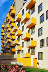 Apartment residential modern house building exterior with flowers and fence. New home concept.
