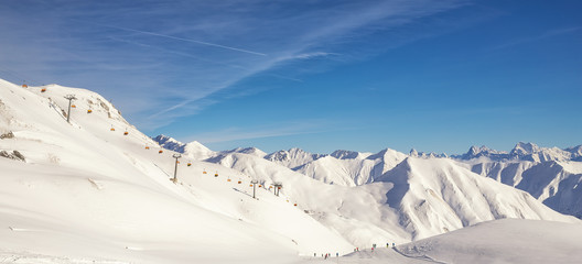 Ski lift ropeway station on hilghland alpine peak at mountain winter resort on bright sunny day....