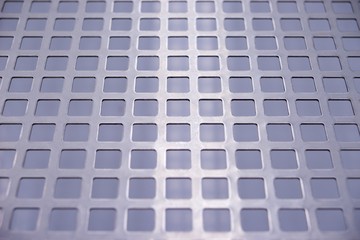 Perforated stainless metal sheet on white background.