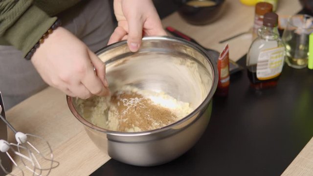 Static shot of a man stiring up ingredients in a bowl.
