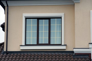 one brown window on the gray wall of the house
