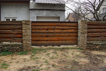 brown wooden gate and brick fence in  street