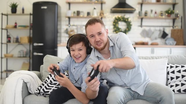 Father and son playing on playstation console. Game competition