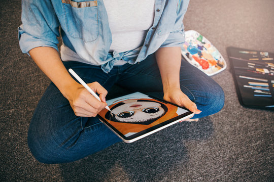Lifestyle creative hobby and freelance artistic work job concept. Caucasian woman artist illustrator painting drawing on touch pad digital tablet with stylus. Process of creating illustration.