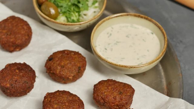 Falafel on plate with tahini and cabbage salad. Falafel on white paper. 