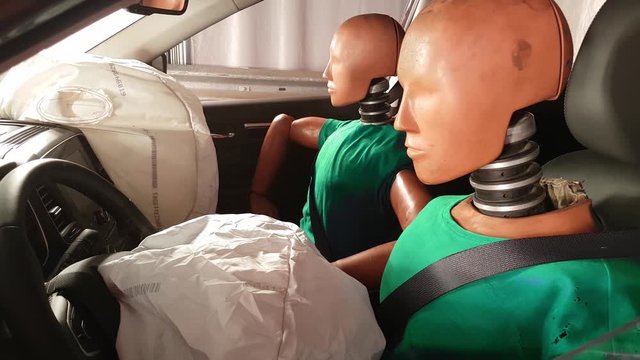 mannequins in car after crash test. Smoke coming out of airbag after an accident