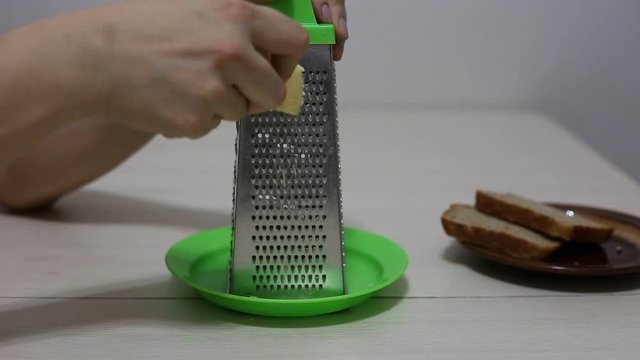 Hands grating cheese. Close-up footage.