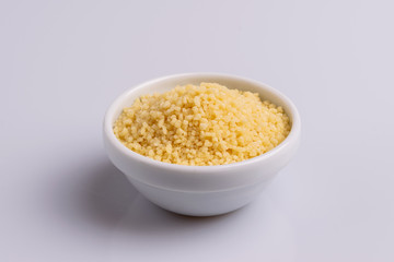 Dry couscous isolated on white background, soft light, copy space.