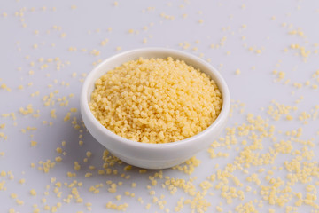 Dry couscous isolated on white background, soft light, copy space.