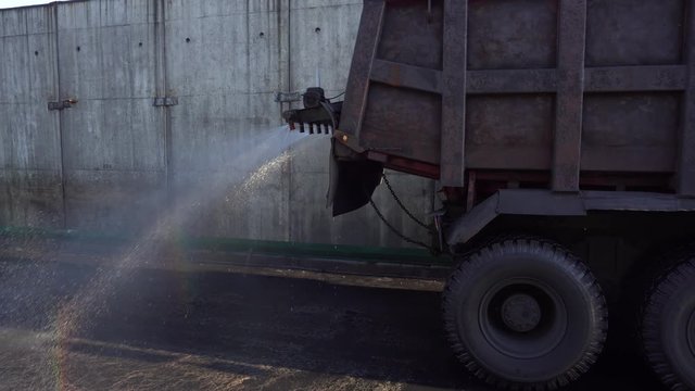 Close-up. The car pours clean asphalt dirty from coal dust in the coal trading port of Nakhodka. Wet cleaning.