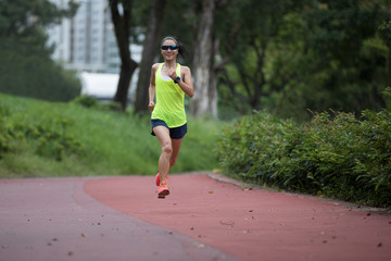 Fitness sporty woman jogger running at outdoors jogging track in park