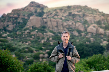 Middle aged man staying healthy by doing outdoor activities during a nature getaway vacation.  He is hiking through the mountains and enjoying the peace and serenity.
