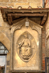 Religious terracotta half-relief on wall in Arezzo, Tuscany, Italy