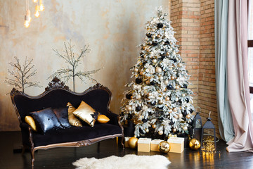Elegant Interior in black and gold colors. Black sofa and gold pillows, room decorated for celebrating New Year. Comfort home in Christmas Holidays. Fashion stylish classic interior with silver spruce