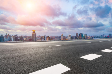 Empty asphalt highway and modern cityscape in Shanghai at sunset.