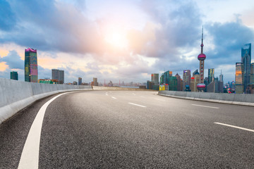 Fototapeta na wymiar Empty asphalt highway and modern cityscape in Shanghai at sunset.