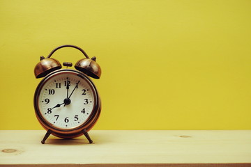 Vintage alarm clock with space copy on yellow background