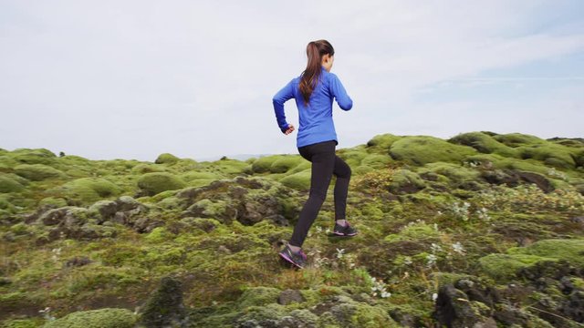 Trail running woman in cross country run. Female runner training jogging outdoors in mountain nature landscape on Iceland. Healthy lifestyle mixed race fitness model. RED EPIC 90 FPS.