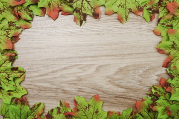 Naklejka na ściany i meble Autumn Maple leave border frame with space copy on wooden background