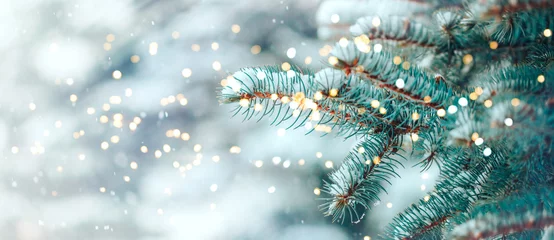 Wandaufkleber Weihnachtsbaum im Freien mit Schnee, Bokeh-Lichtern und Schneefall, Weihnachtsatmosphäre. © Anastassiya 
