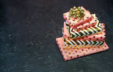 Gifts Wrapped In Pink And Gold on a black background.