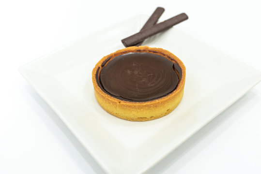Chocolate turd tart pie. Home made baked. Empty copy space for text. White plate background.
