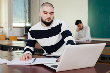 Fototapeta premium Young guy studying with laptop