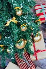 Christmas background. Green fir tree with golden balls and gift boxes. - 303988511