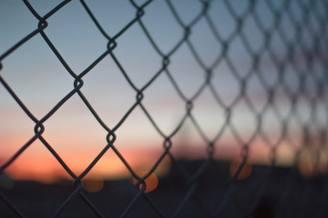 Metal chain fence during a sunset