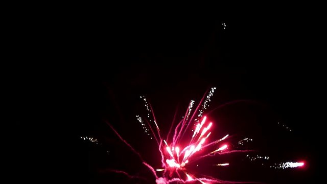 Explosion of bright colorful part of fireworks on black background to create a set salute on video for holiday new year, birthday, wedding or other celebration.