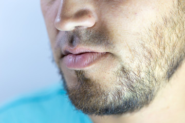Bearded young man, stubble near. Unshaven more than a week. Hair on the face of a man, a short beard.