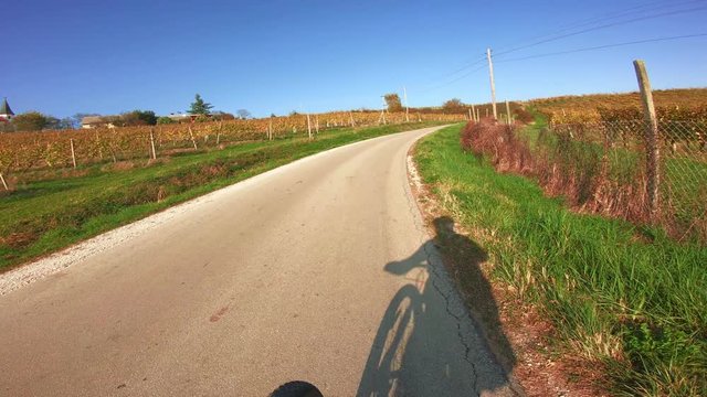 Cycling on steep road, shadow of biker on pavement, steep uphil climp, struglle to keep direction