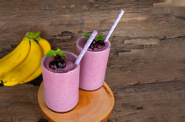 Blueberry mix banana smoothies purple colorful fruit juice milkshake blend beverage healthy high protein taste yummy drink in glass morning on wooden background.