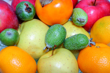 feijoa apples tangerines fruits on the whole frame as background