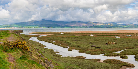 Boats in the grass, with clouds over the Lake District National Park in the background, seen in...
