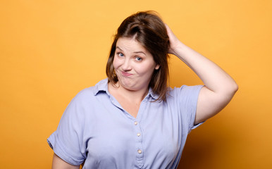 thoughtful emotional plus size model on a yellow background