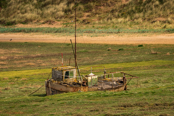 The wreck of a boat in the grass, seen in Askam-in-Furness, Cumbria, England, UK