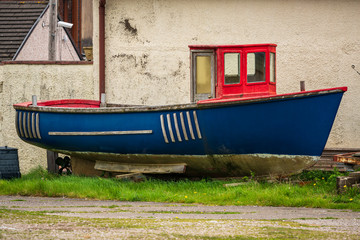 Fototapeta na wymiar An old boat in front of a house, seen in Millom, Cumbria, England, UK