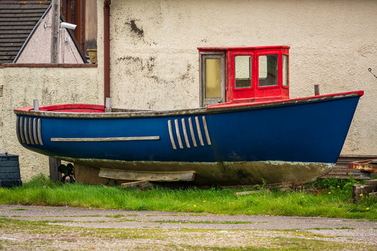 An old boat in front of a house, seen in Millom, Cumbria, England, UK