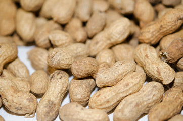 Unshelled peanuts close-up. Lots of nuts, vegan, natural food.